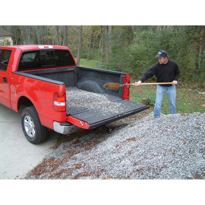 A red truck with a BedRug Truck 20+ GM HD Silverado/Sierra 6'9" Bed w/ Multi-Pro Tailgate Bed Liner and a man shoveling gravel from the bed.