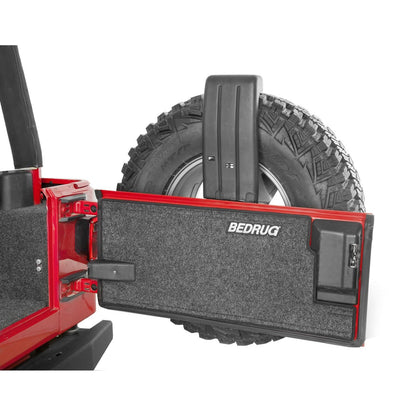 BedRug Jeep Tailgate 97-06 Jeep Tj/Lj Tailgate Mat - Charcoal (BRTJTG) installed on a red Jeep tire.