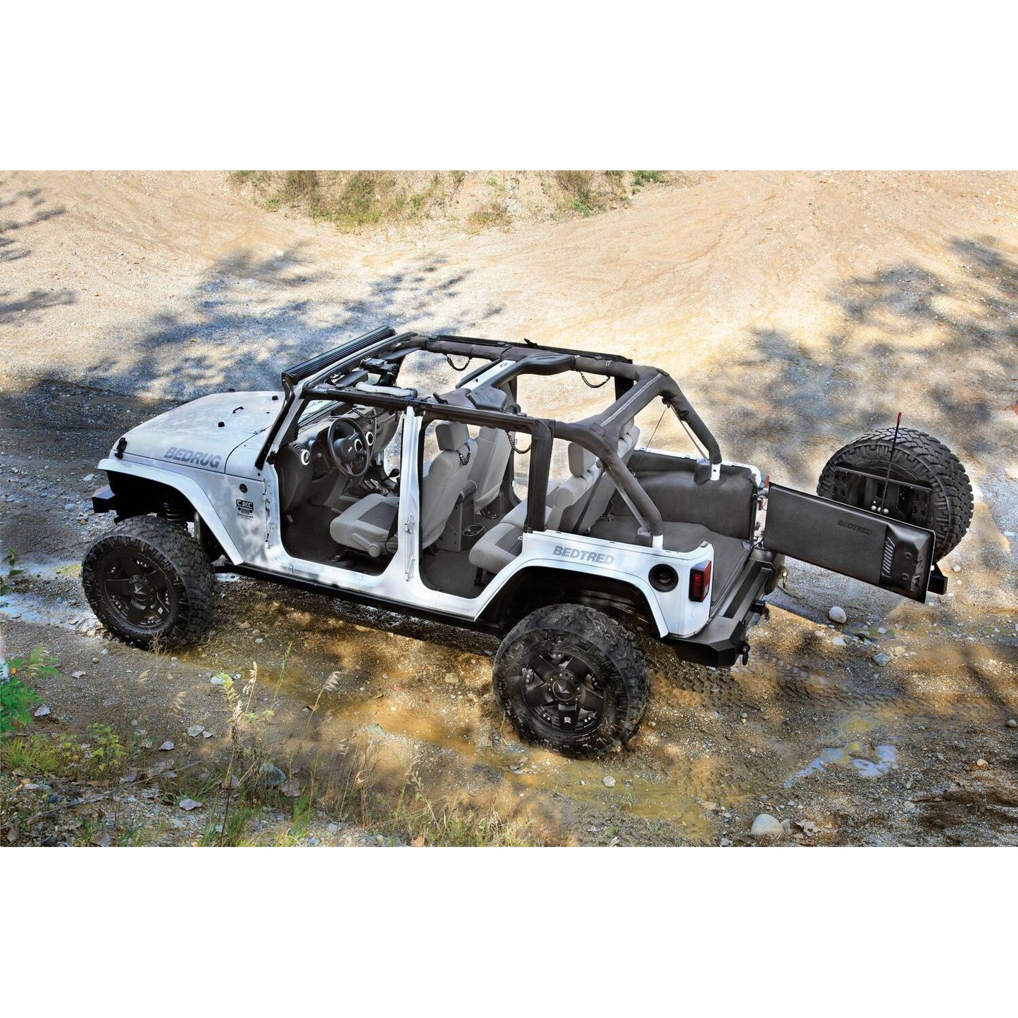 BedRug Jeep Bedtred 11-18 JK Unltd 4Dr Rear 5Pc Cargo Kit Rear Kit Incl. Drivers Wheel Well/ Passengers Wheel Well/ Rear Cargo Floor/ Tailgate And Tub Liner Bed Liner - Charcoal (BTJK11R4) on rugged terrain.